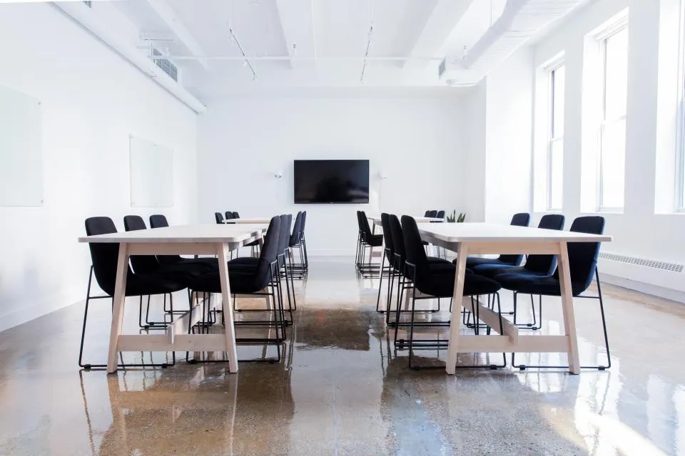Bright meeting room with tables and a screen