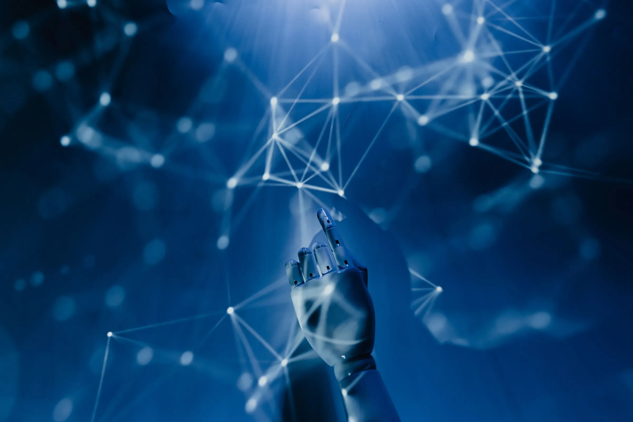 Robotic hand reaching into a glowing digital network