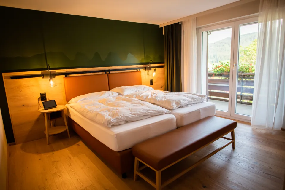 Warmly lit hotel room with a double bed